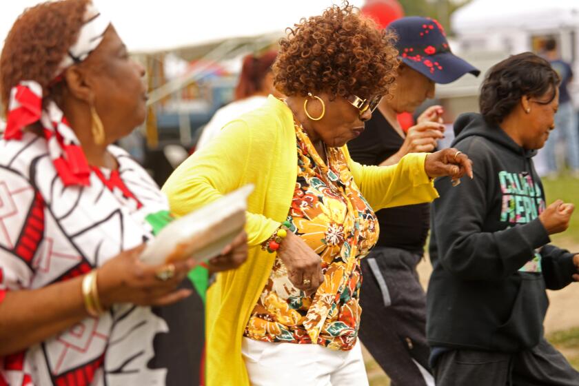 LONG BEACH, CA - JUNE 18, 2023 - Geneva Johnson, left, and her sister Dorothy Nichols, center, dance with others at the Juneteenth celebration in Martin Luther King Jr. Park in Long Beach on June 18, 2023. The day started with an outdoor service by the Grace Memorial Baptist Church, a breakfast, and many set up booths selling t-shirts and some providing information on various programs to help members in the community. Music was provided featuring singer Demetri Thomas. Juneteenth is a federal holiday commemorating the emancipation of enslaved African Americans. Juneteenth combines June and nineteenth when Texas declared freedom for slaves on June 19, 1865, two and a half years after the Emancipation Proclamation was issued. (Genaro Molina / Los Angeles Times)