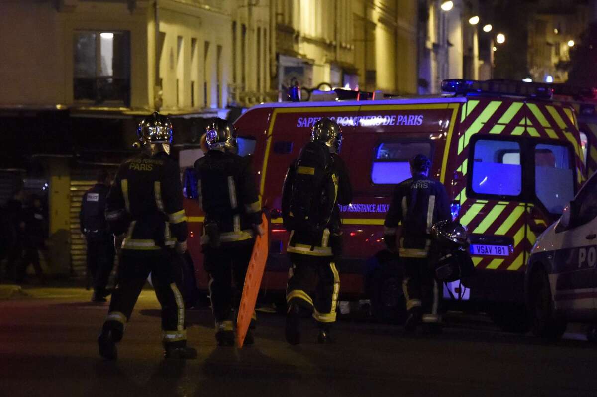 Police and other emergency workers secure the area following an attack at the Bataclan concert hall in central Paris on Friday.