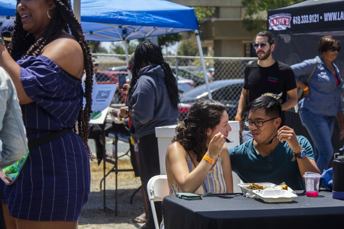 Andrea Escobar and Jordan Tanap enjoy their food at the Soul Food Festival in City Heights on Saturday