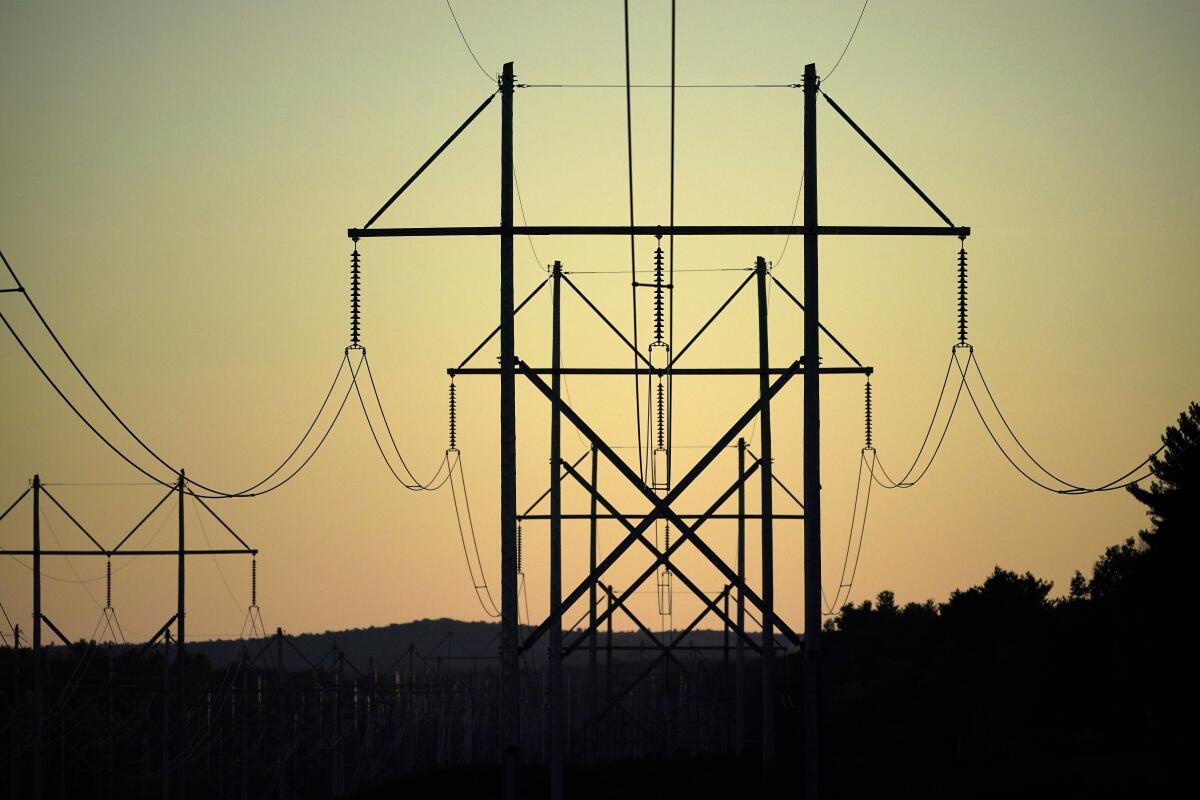 Power utility lines against an orange sky