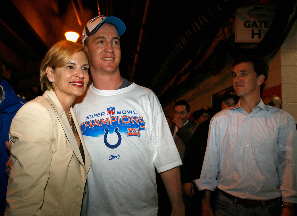 Olivia Manning poses for a photo with her son Peyton Manning while his brother Cooper looks on.