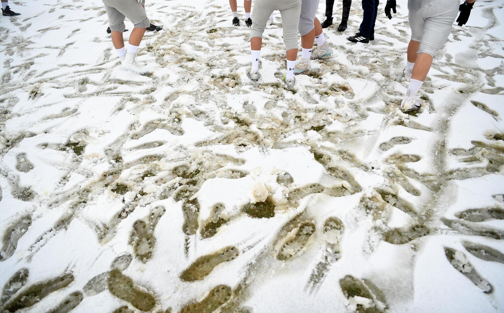 Rim of the World High School football players practice after a snowstorm in Rimforest on Tuesday.