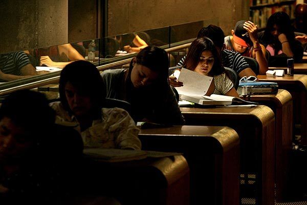 Students doing homework fill a row of desks in the library at Santa Monica College. Many community college students are finding that they can't finish or transfer in the amount of time they'd expected because class offerings have been reduced because of state budget cuts.
