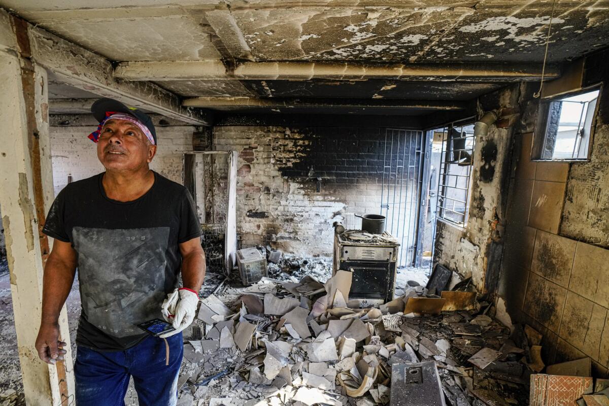 Marco Delgadillo observa los daños en su hogar tras un incendio en el barrio de El Oliva