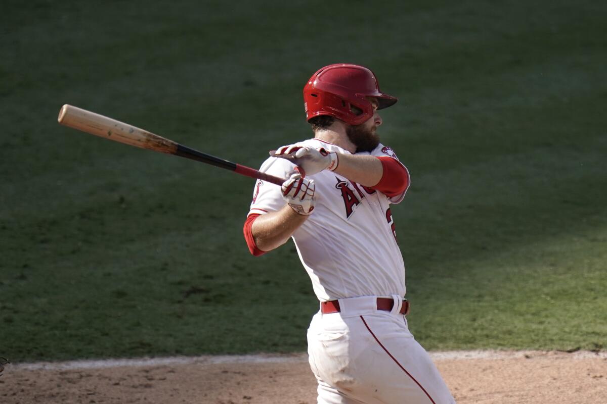 Los Angeles Angels' Jared Walsh follows through after hitting an RBI single during the eighth inning.