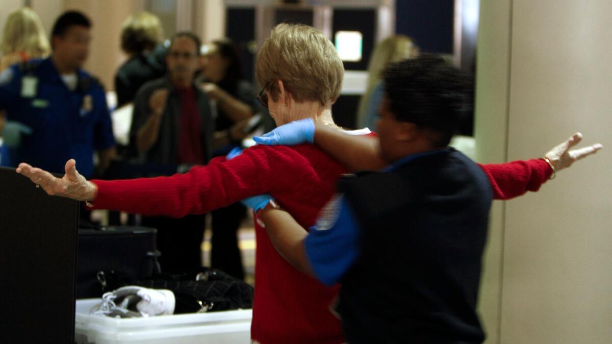 A traveler undergoes a pat down from a TSA screener at Los Angeles International Airport. The Transportation Security Administration has implemented a new pat-down procedure.