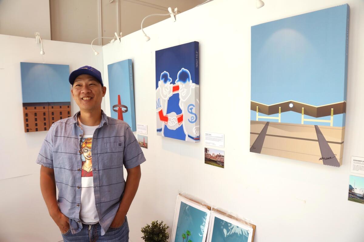 S. Preston stands next to some of his art from the "Minimalist MLB Ballpark" series.
