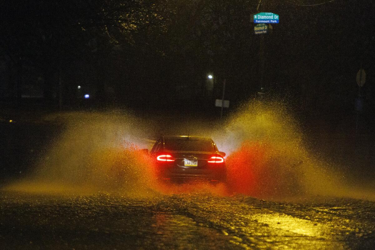 A car drives on a flooded street in Philadelphia early Monday.