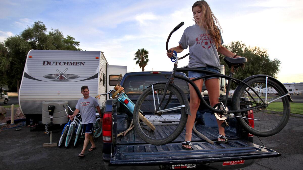 Carlos and Isabela Meza of Modesto unload their bikes as they set up camp for the night at the KOA campground.