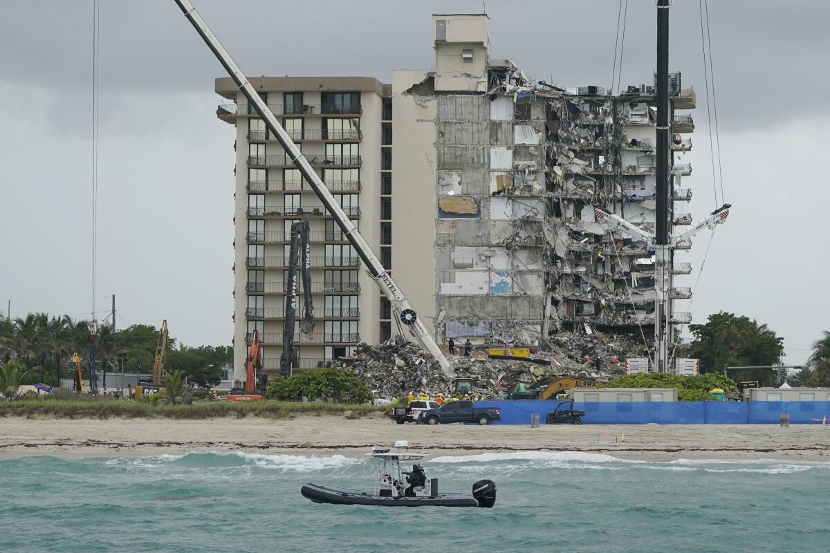 A law enforcement boat patrols in front of the partially collapsed Champlain Towers South condo building.