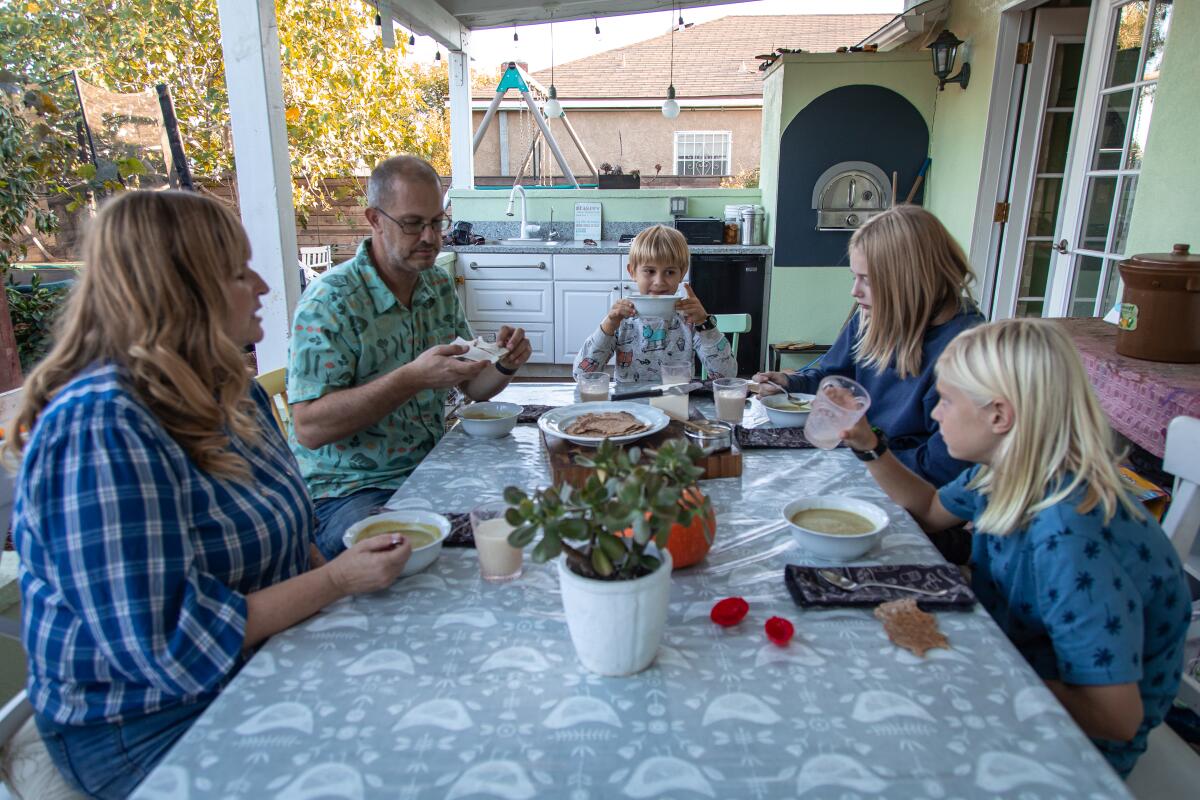 Their back porch has become the Syren family's dining area as Fredrika, James, Liam, Bella and Noah enjoy homemade soup. 