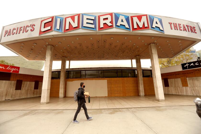 HOLLYWOOD, CA - APRIL 13, 2021 - - A pedestrian walks past the Cinerama Dome in Hollywood on April 13, 2021. ArcLight Cinemas and Pacific Theaters said late Monday they are ceasing operations, closing all of their roughly 300 screens mostly found in California. Hollywood heavyweights are rallying to save ArcLight Cinemas after the owner of the beloved theater chain announced that its doors would not reopen after the COVID-19 pandemic took an extreme financial toll on the moviegoing industry. The jointly owned ArcLight and Pacific theaters will both remain closed after shutting down due to the public health emergency, Pacific Theatres said Monday in a statement. It said, "Despite a huge effort that exhausted all potential options, the company does not have a viable way forward." (Genaro Molina / Los Angeles Times)