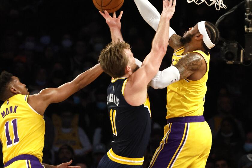 LOS ANGELES, CA - JANUARY 19, 2022: Los Angeles Lakers forward Carmelo Anthony (7) blocks the shot of Indiana Pacers forward Domantas Sabonis (11) with Los Angeles Lakers guard Malik Monk (11) defending on the left in the first half at Crypto.com arena on January 19, 2022 in Los Angeles, California.(Gina Ferazzi / Los Angeles Times)