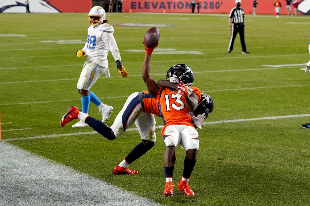 Denver Broncos' K.J. Hamler is pulled to the ground by a teammate as they celebrate Hamler's touchdown against the Chargers