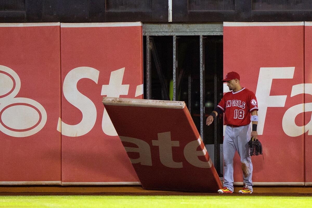Angels outfielder Shane Victorino watches as a piece of the outfield wall falls onto the field during the fifth inning at O.co Coliseum.