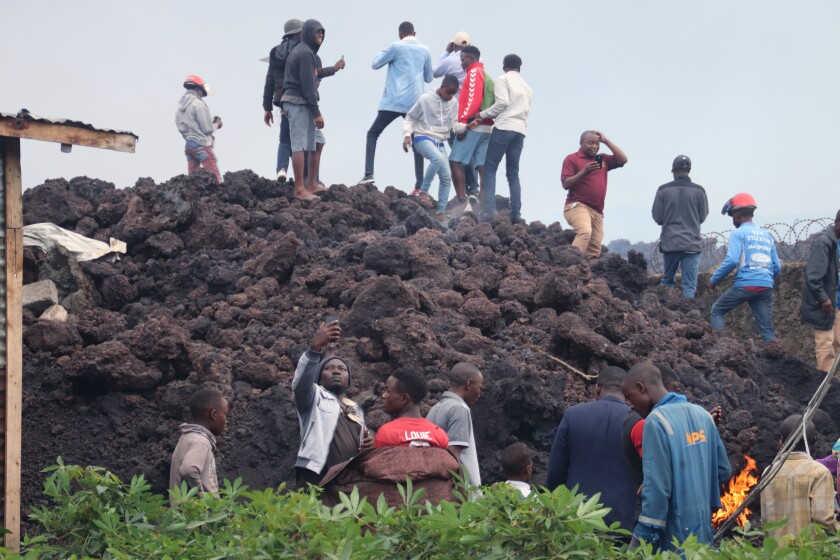 People gather on a stream of cold lava rock following the overnight eruption of Mount Nyiragongo in Goma, Congo, Sunday, May 23, 2021. Witnesses say Congo’s Mount Nyiragongo volcano unleashed lava that destroyed homes on the outskirts of Goma but the city of nearly 2 million was mostly spared after the nighttime eruption. Residents of the Buhene area said many homes had caught fire as lava oozed into their neighborhood. (AP Photo/Justin Kabumba)