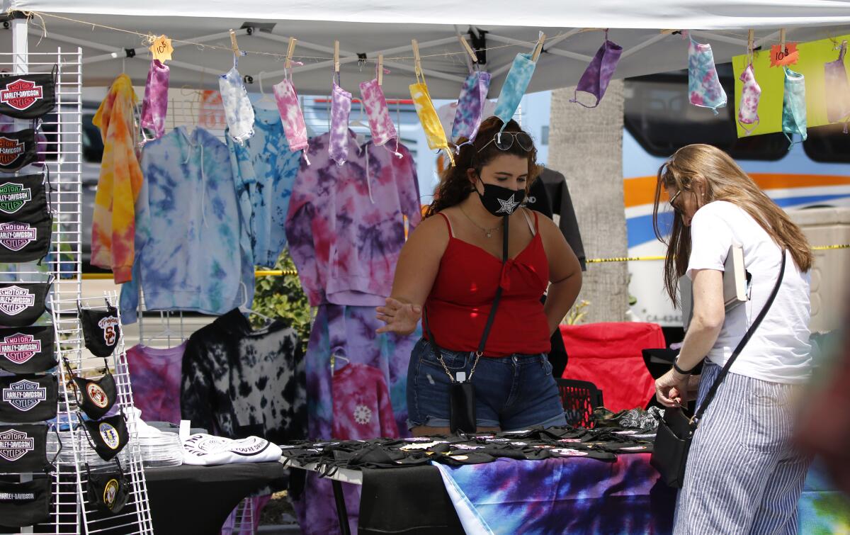 Taylor Medina of Chino Hills sells masks and other items of clothing at her stand.