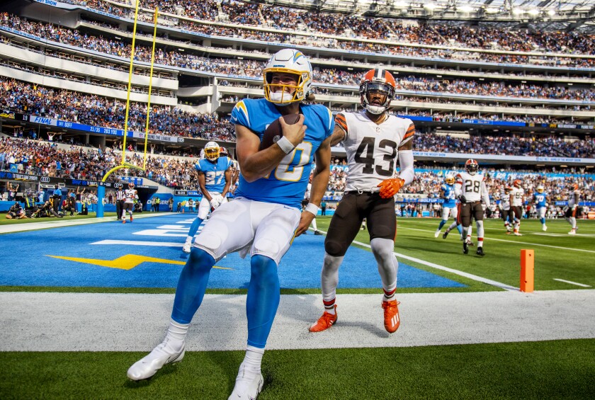 O quarterback do Chargers, Justin Herbert, sorri após marcar um touchdown de nove jardas.
