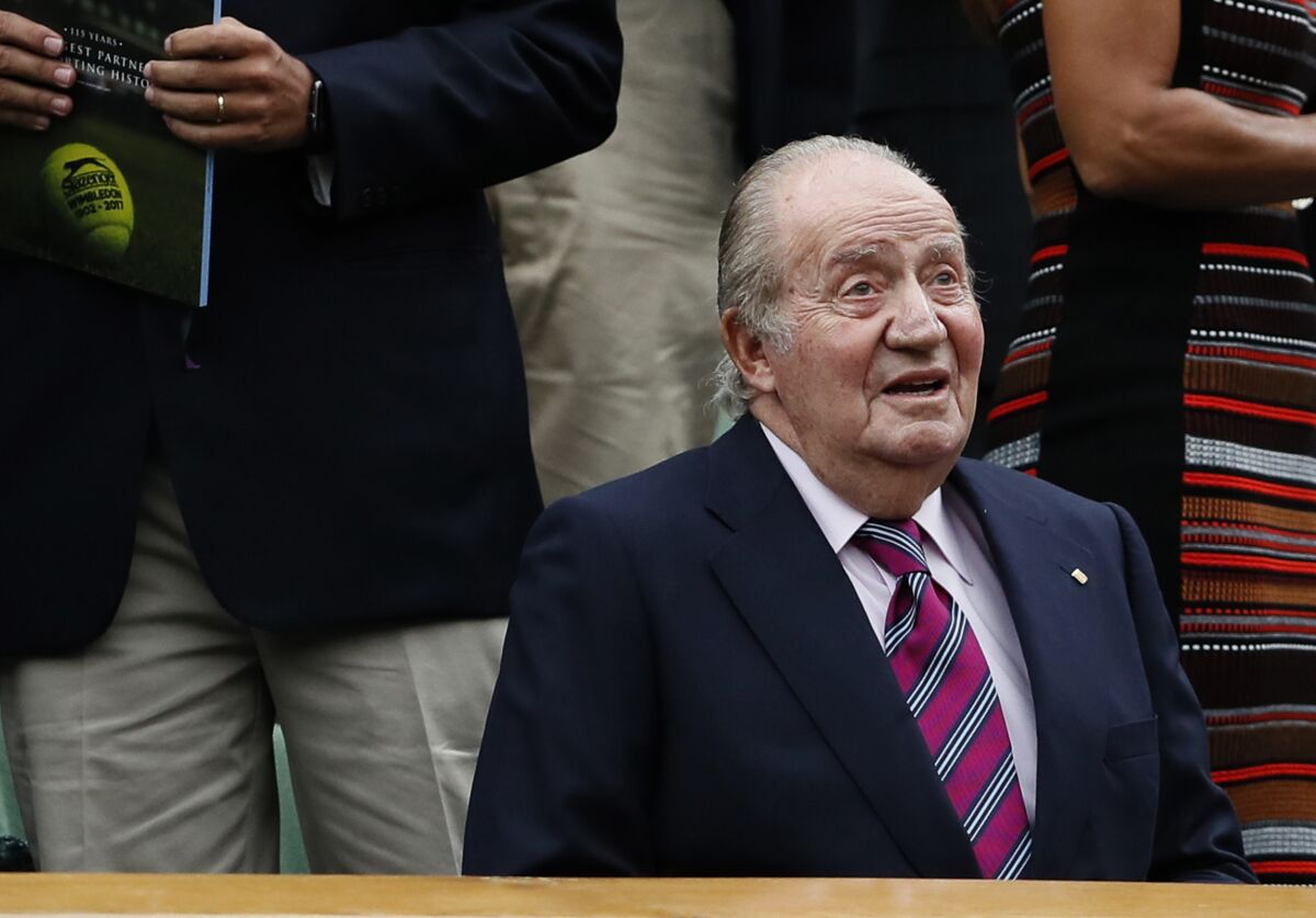 FILE - Former Spanish King Juan Carlos takes his seat for the Women's Singles final match between Venus Williams of the United States and Spain's Garbine Muguruza on day twelve at the Wimbledon Tennis Championships in London, on July 15, 2017. Geneva prosecutors have fined a Swiss bank for failing to alert money laundering authorities about millions in funds from Saudi Arabia that went to former Spanish King Juan Carlos and his ex-lover, but have dropped any charges against his associates in the case. (AP Photo/Kirsty Wigglesworth, File)