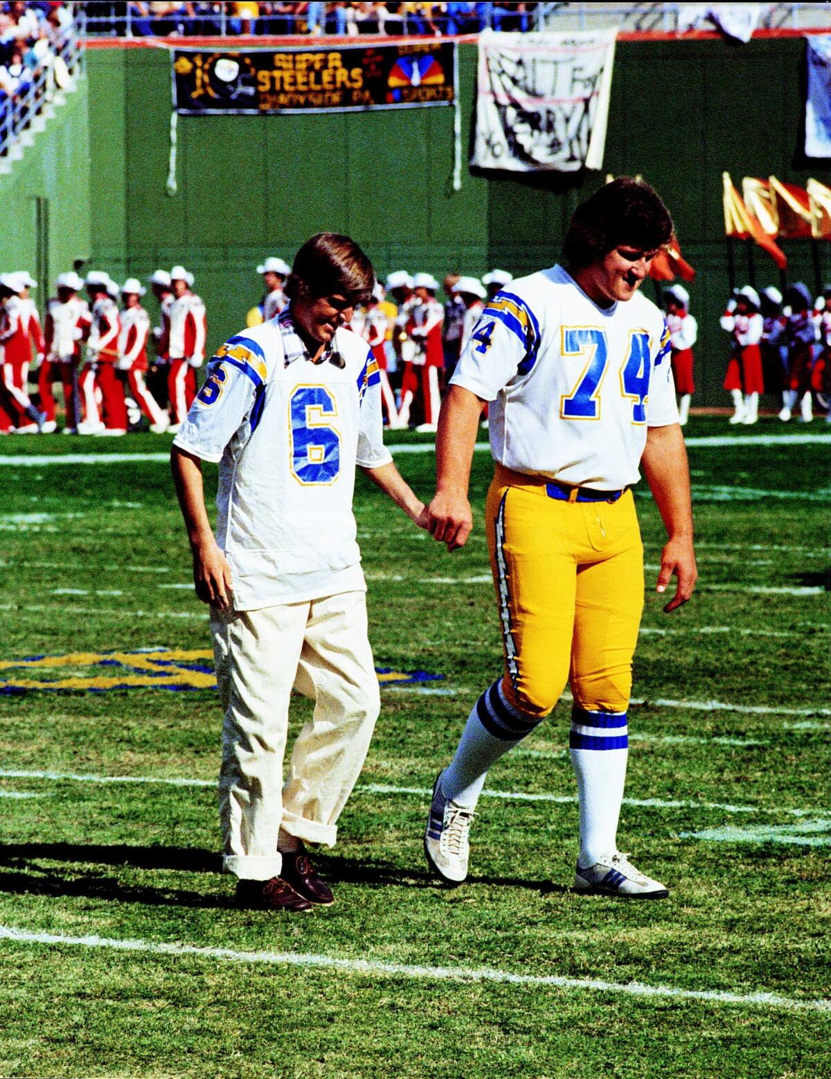 Chargers kicker Rolf Benirschke joins Louie Kelcher (74) to participate in the coin toss before the Chargers-Steelers game. 