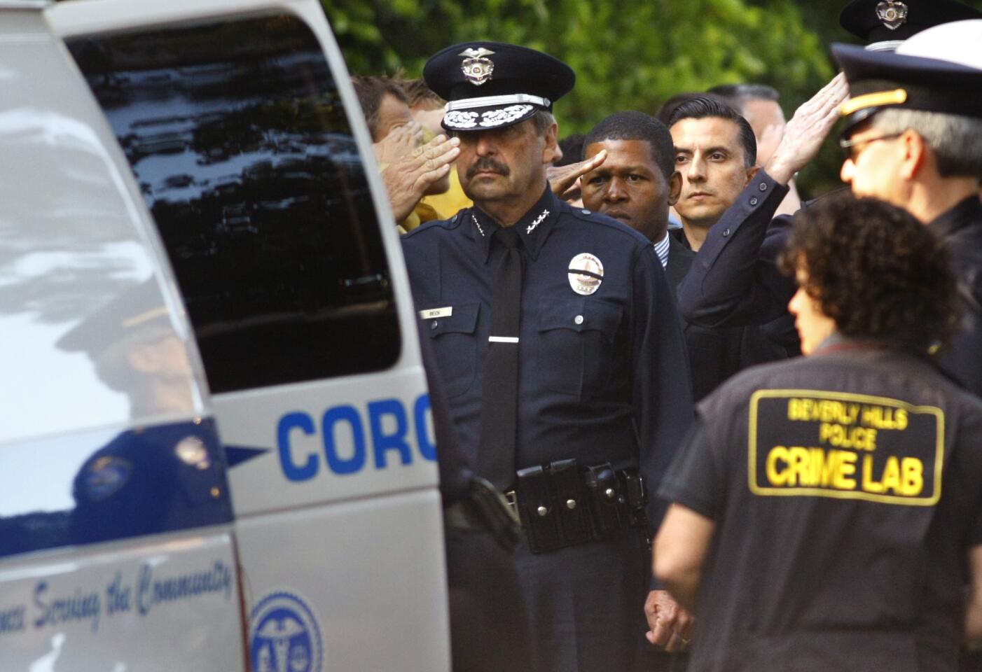 LAPD Chief Charlie Beck salutes as the body of an off-duty police officer killed in an accident with a cement truck is placed into the coroner's van