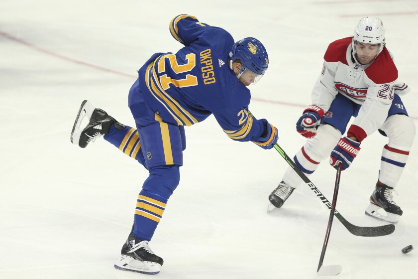Buffalo Sabres right wing Kyle Okposo (21) shoots while defended by Montreal Canadiens defenseman Chris Wideman (20) during the third period of an NHL hockey game on Friday, Nov. 26, 2021, in Buffalo, N.Y. (AP Photo/Joshua Bessex)