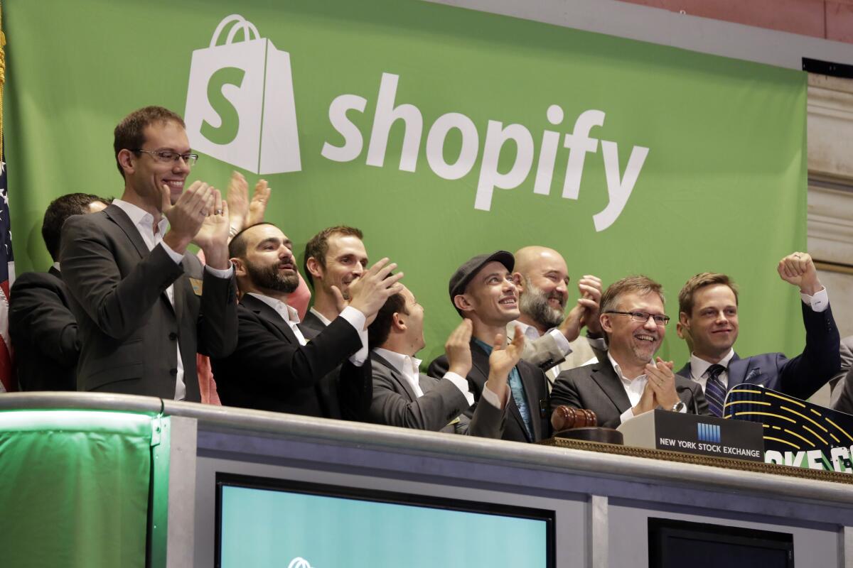 Shopify CEO Tobias Lutke, center wearing hat, is celebrated as he rings the New York Stock Exchange opening bell.