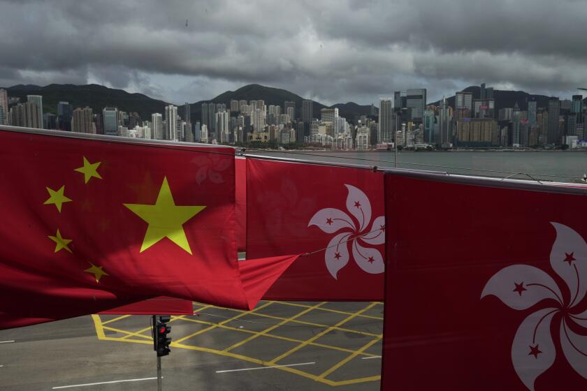 Chinese and Hong Kong flags are hanged to celebrate the 25th anniversary of Hong Kong handover to China, in Hong Kong, Friday, June 17, 2022. Hong Kong is preparing to introduce new middle school textbooks that will deny the Chinese territory was ever a British colony. (AP Photo/Kin Cheung)