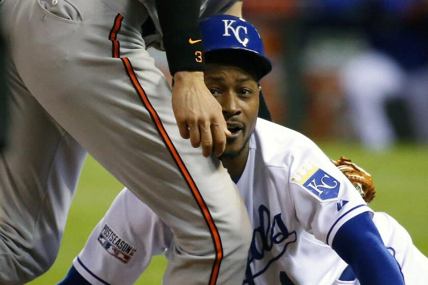 Kansas City's Jarrod Dyson meets with the leg of Baltimore's Ryan Flaherty while diving back to third base on Tuesday night.