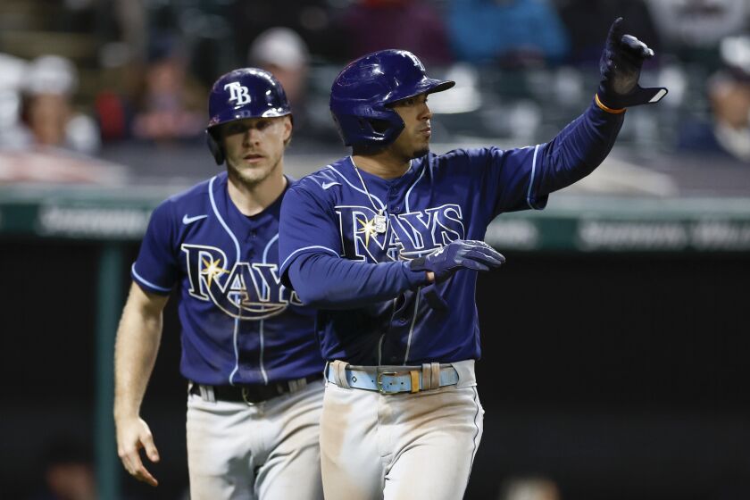 Tampa Bay Rays' Taylor Walls, left, and Wander Franco celebrate after scoring on a double by Harold Ramirez during the 11th inning of a baseball game against the Cleveland Guardians, Tuesday, Sept. 27, 2022, in Cleveland. (AP Photo/Ron Schwane)