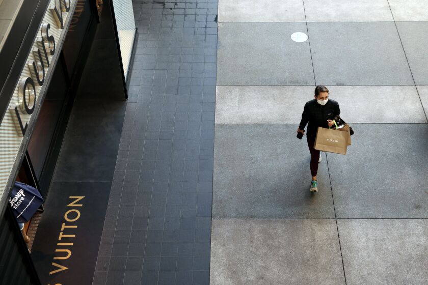 SANTA MONICA-CA-NOVEMBER 13 2020: A lone shopper passes by the Louis Vuitton store at Santa Monica Place on Friday, November 13, 2020. (Christina House / Los Angeles Times)
