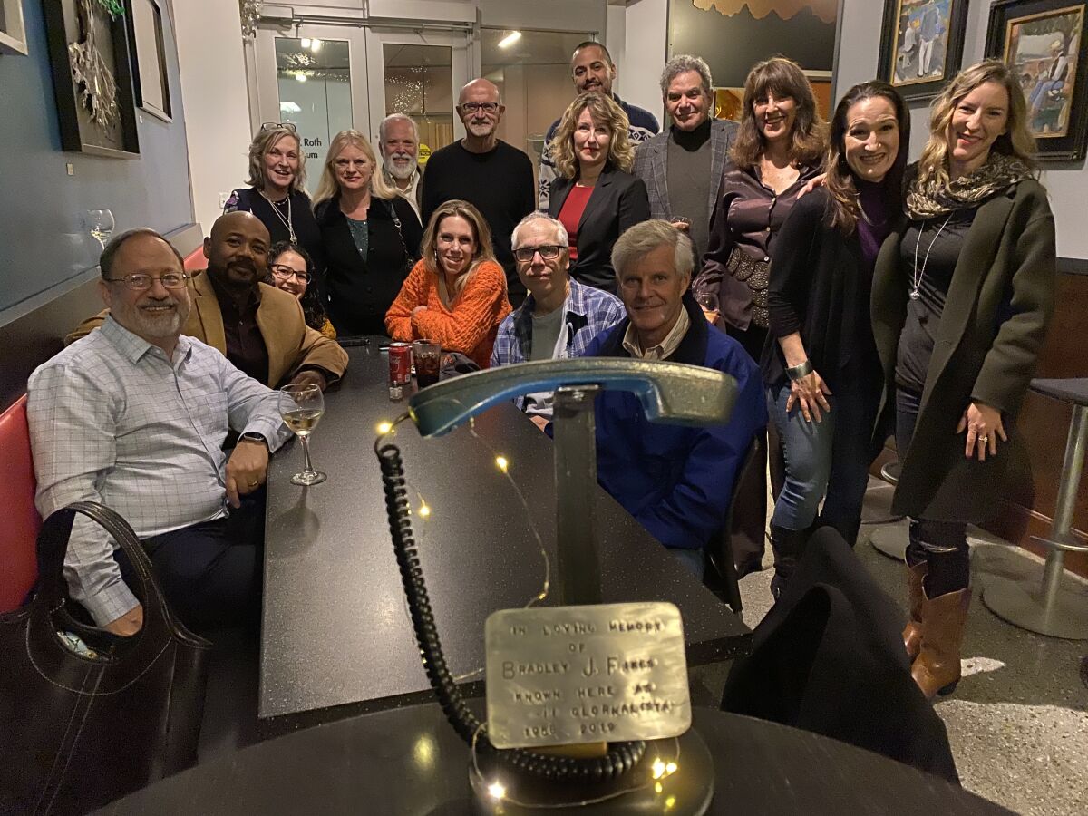 Friends, family, colleagues and biotech execs gather to remember Bradley Fikes at his favorite restaurant, the Bella Vista Caffe in La Jolla, Dec. 13. In the foreground is a plaque the restaurant had made in his memory.