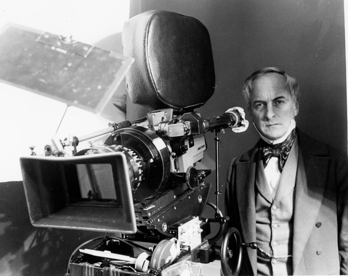 James Ivory in a vintage suit behind a movie camera   