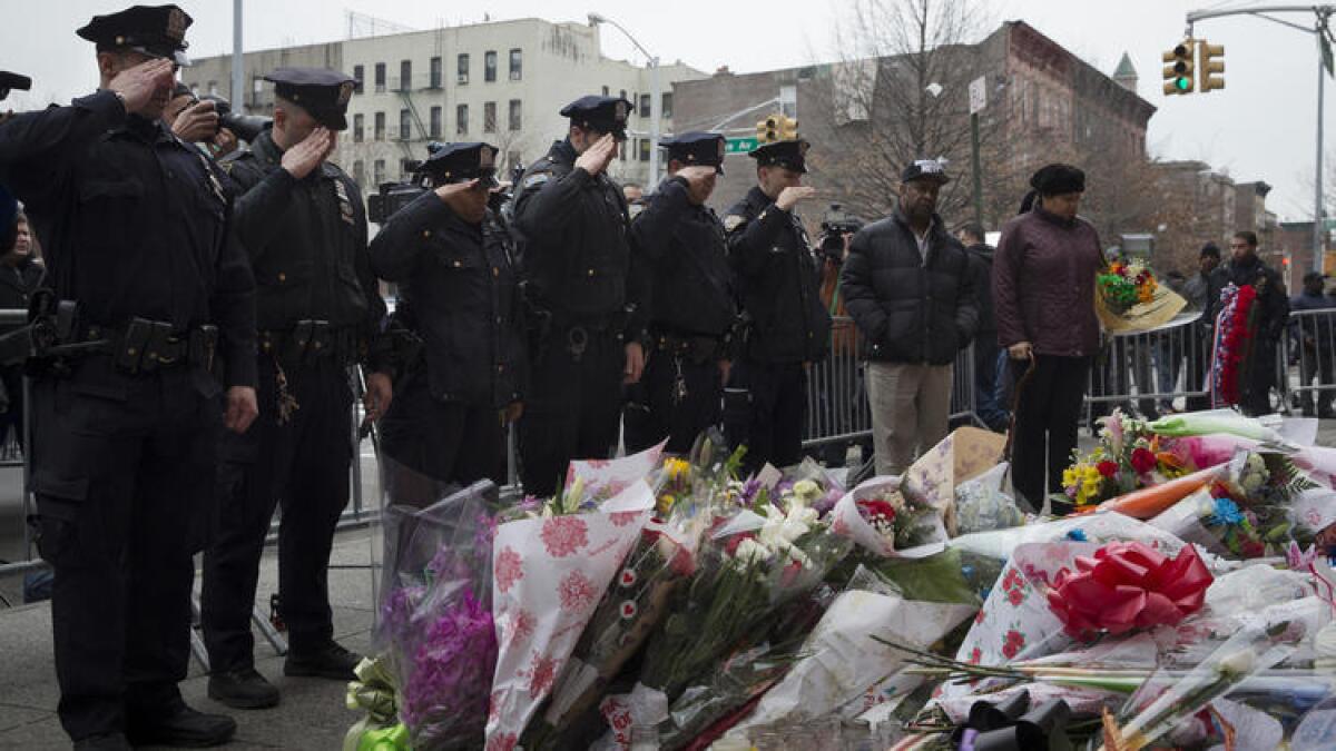 Oficiales rinden homenaje ante un memorial improvisado colocado cerca del sitio en donde los oficiales de la policía de la ciudad de Nueva York, Rafael Ramos y Wenjian Liu, fueron emboscados y asesinados en Brooklyn en el mes de diciembre del 2014.