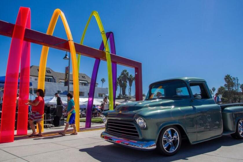 A classic Chevy pickup sits parked by the Imperial Beach sign.