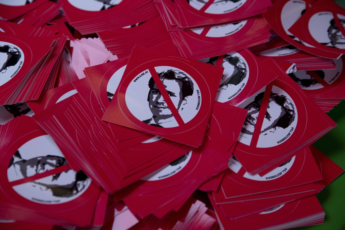 Stickers with a portrait of Austrian Chancellor Sebastian Kurz are being distributed during a protest in Vienna, Austria, Thursday, Oct. 7, 2021. Austrian Chancellor Sebastian Kurz is denying wrongdoing and making clear he doesn't plan to step down despite being under investigation in a bribery probe. However, the partner party in Kurz's coalition government said Thursday that the allegations left a “disastrous” impression and raised questions about the chancellor’s “ability to act.” (AP Photo/Lisa Leutner)
