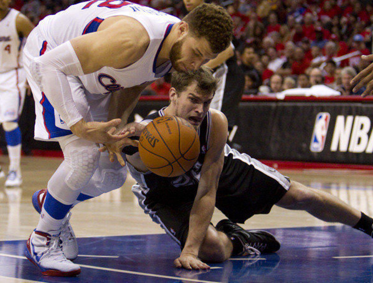 Clippers Blake Griffin and Spurs Tiago Splitter scramble for a loose ball.