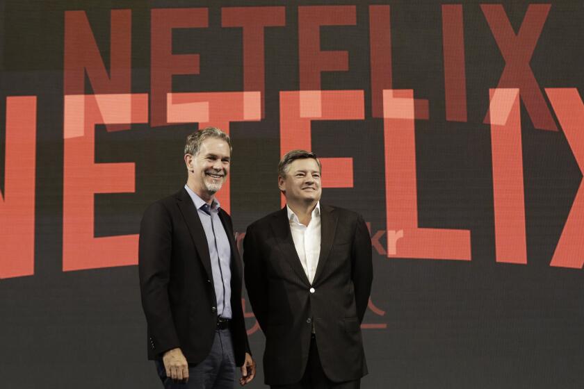 FILE - In this Thursday, June 30, 2016, file photo, Netflix CEO Reed Hastings, left, poses with Ted Sarandos, chief content officer of Netflix, during a news conference in Seoul, South Korea. Netflix added a flood of new subscribers amid the coronavirus pandemic and also offered clues to a possible successor for founding CEO Hastings, who on Thursday, July 16, 2020, named Sarandos, as co-CEO. (AP Photo/Ahn Young-joon, File)