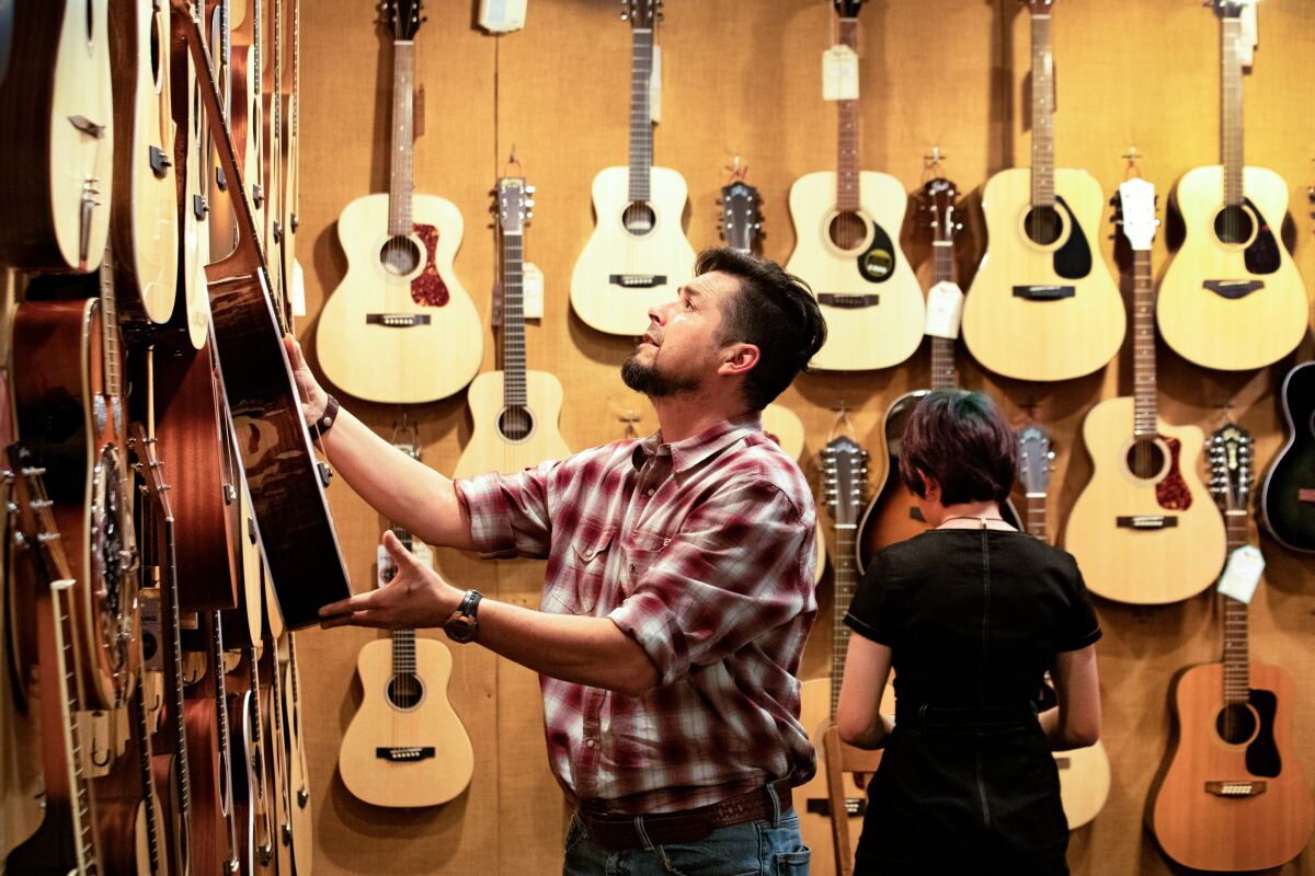 Two people in a music rooms at McCabe's Guitar Shop.