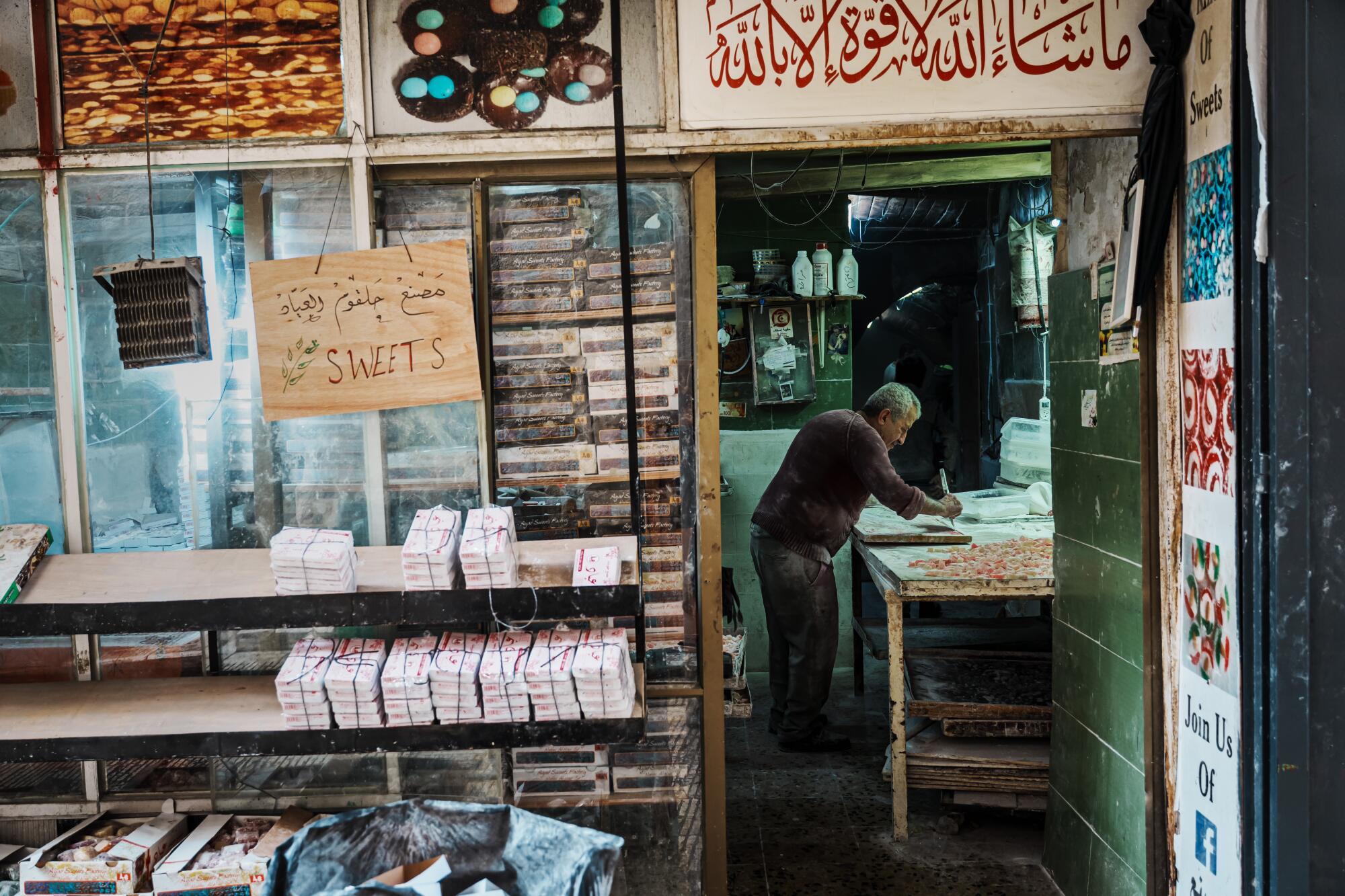 A dessert maker, seen through the doorway of his West Bank shop, cutsTurkish delight into cubes.