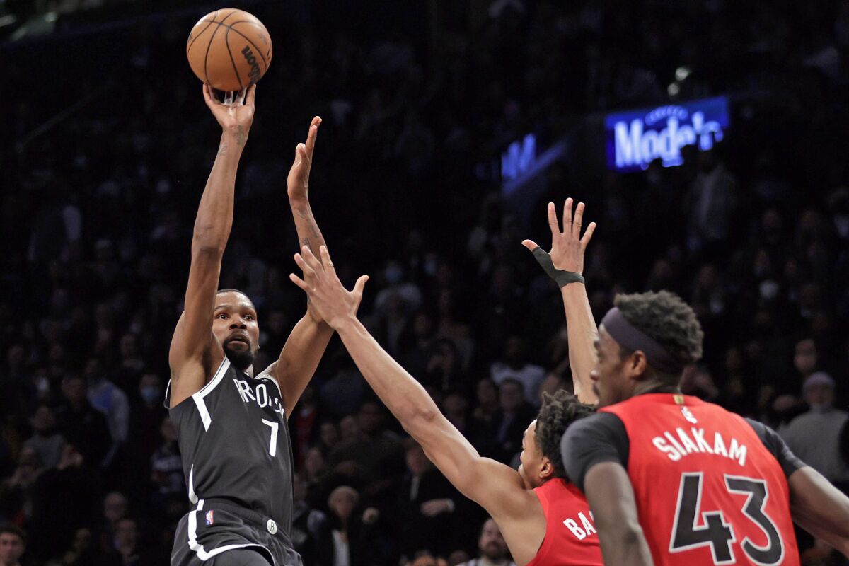 Brooklyn Nets forward Kevin Durant (7) shoots over Toronto Raptors forward Scottie Barnes during the second half of an NBA basketball game Tuesday, Dec. 14, 2021, in New York. The Nets won 131-129 in overtime. (AP Photo/Adam Hunger)
