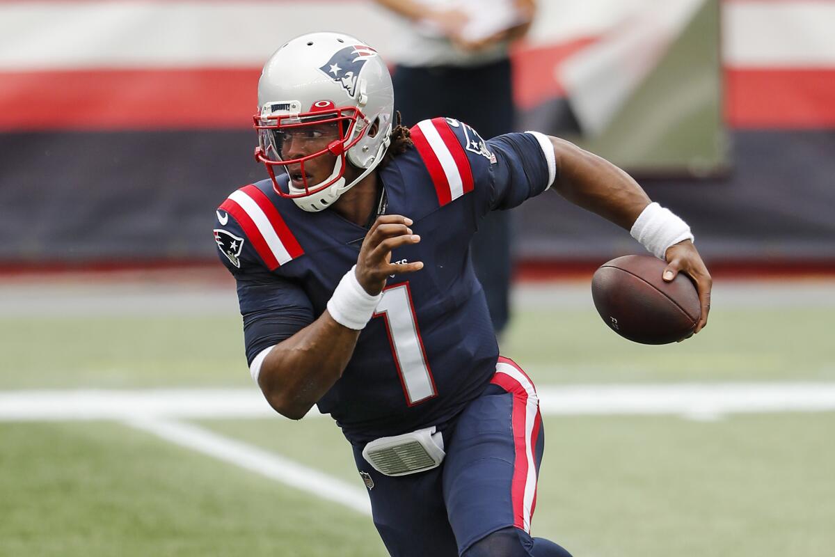 New England Patriots quarterback Cam Newton runs with the ball.