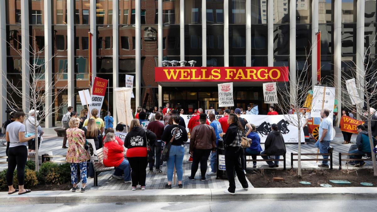 Protesters rally outside the Wells Fargo bank downtown branch April 24 in Des Moines. Late Tuesday, a federal judge in San Francisco signed off on a $480 million settlement in a class-action shareholder lawsuit over the bank's unauthorized-accounts scandal.