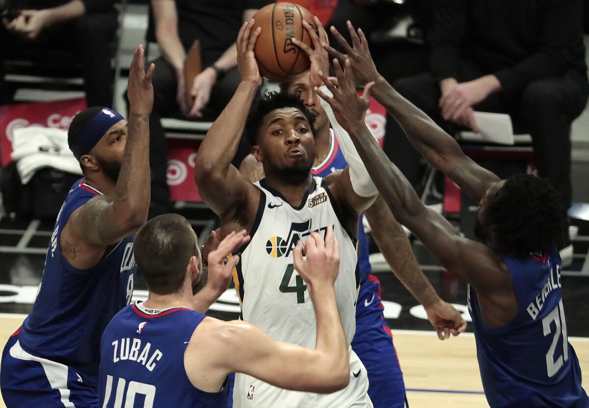 Utah Jazz guard Donovan Mitchell is surrounded by Clippers defenders.