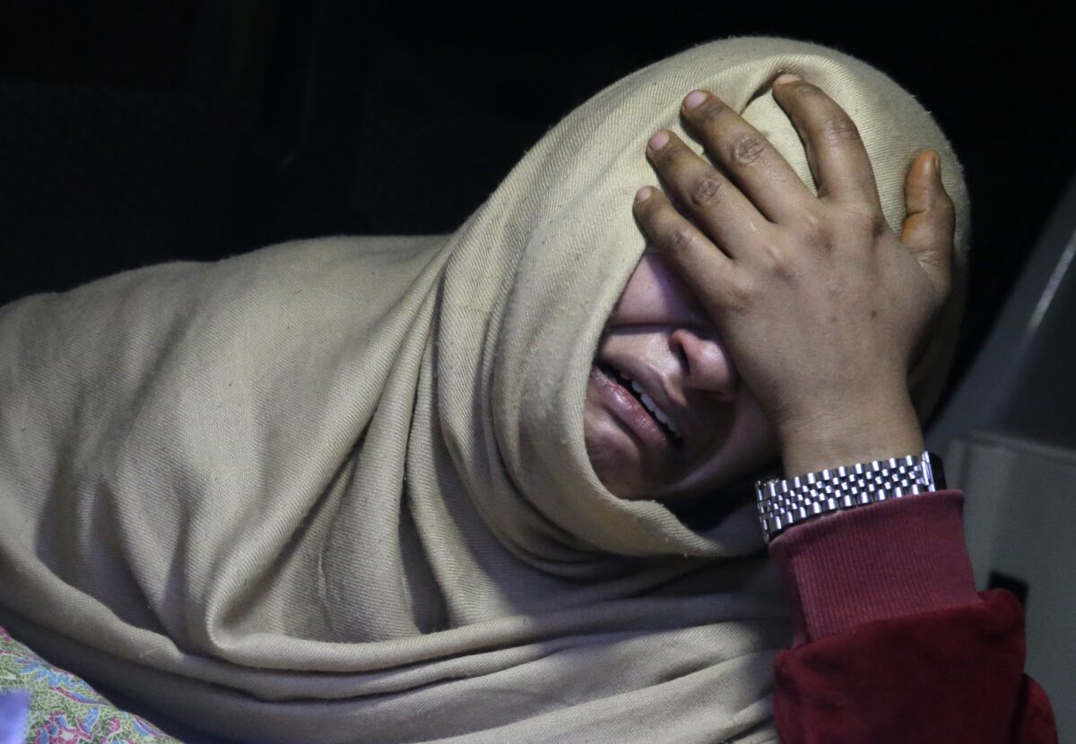 A woman cries inside an ambulance after she lost her family member during a heavy snowfall-hit area in Murree, some 28 miles (45 kilometers) north of the capital of Islamabad, Pakistan, Saturday, Jan. 8, 2022. Temperatures fell to minus 8 degrees Celsius (17.6 Fahrenheit) amid heavy snowfall at Pakistan's mountain resort town of Murree overnight, killing multiple people who were stuck in their vehicles, officials said Saturday. (AP Photo/Rahmat Gul)