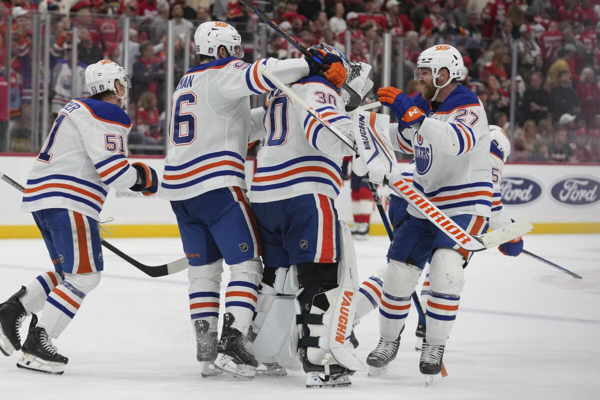 Edmonton Oilers players celebrate with goaltender Calvin Pickard after defeating the Florida Panthers.