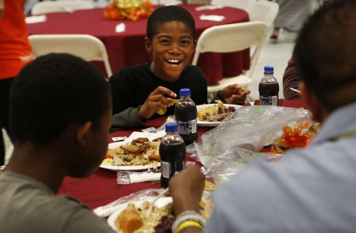 Jaisean Woodso, 9, smiles as he enjoys a turkey dinner at the Union Rescue Mission in Los Angeles last fall. Charitable giving may have reached a new record in 2013, a group estimates.
