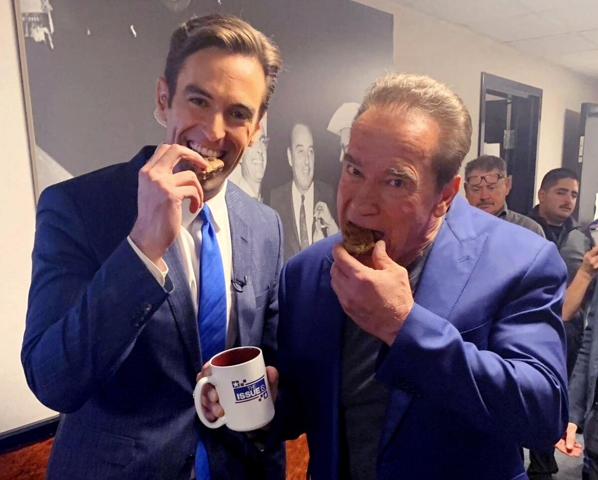  Elex Michaelson and former Gov. Arnold Schwarzenegger eating cookies