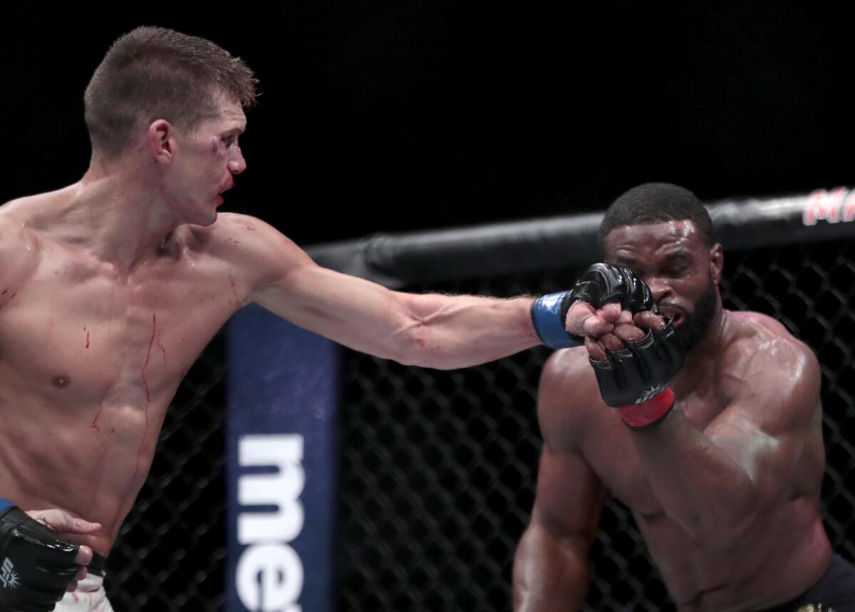 Stephen Thompson, left, connects with a left against Tyron Woodley during their welterweight title fight at UFC 205.