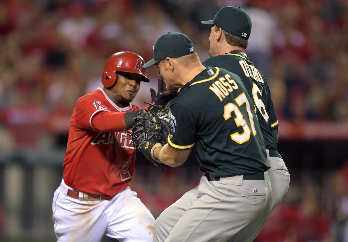 Dan Otero appears to tag out Erick Aybar as Aybar runs to first base while Brandon Moss looks on.